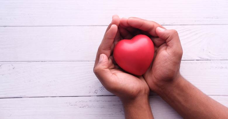 A pair of hands holding a rubber heart